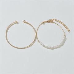 Two exquisite gold bangles with pearls and a chain, highlighting the beauty of the Pearl & 18K Gold-Plated Oval Bracelet Set.
