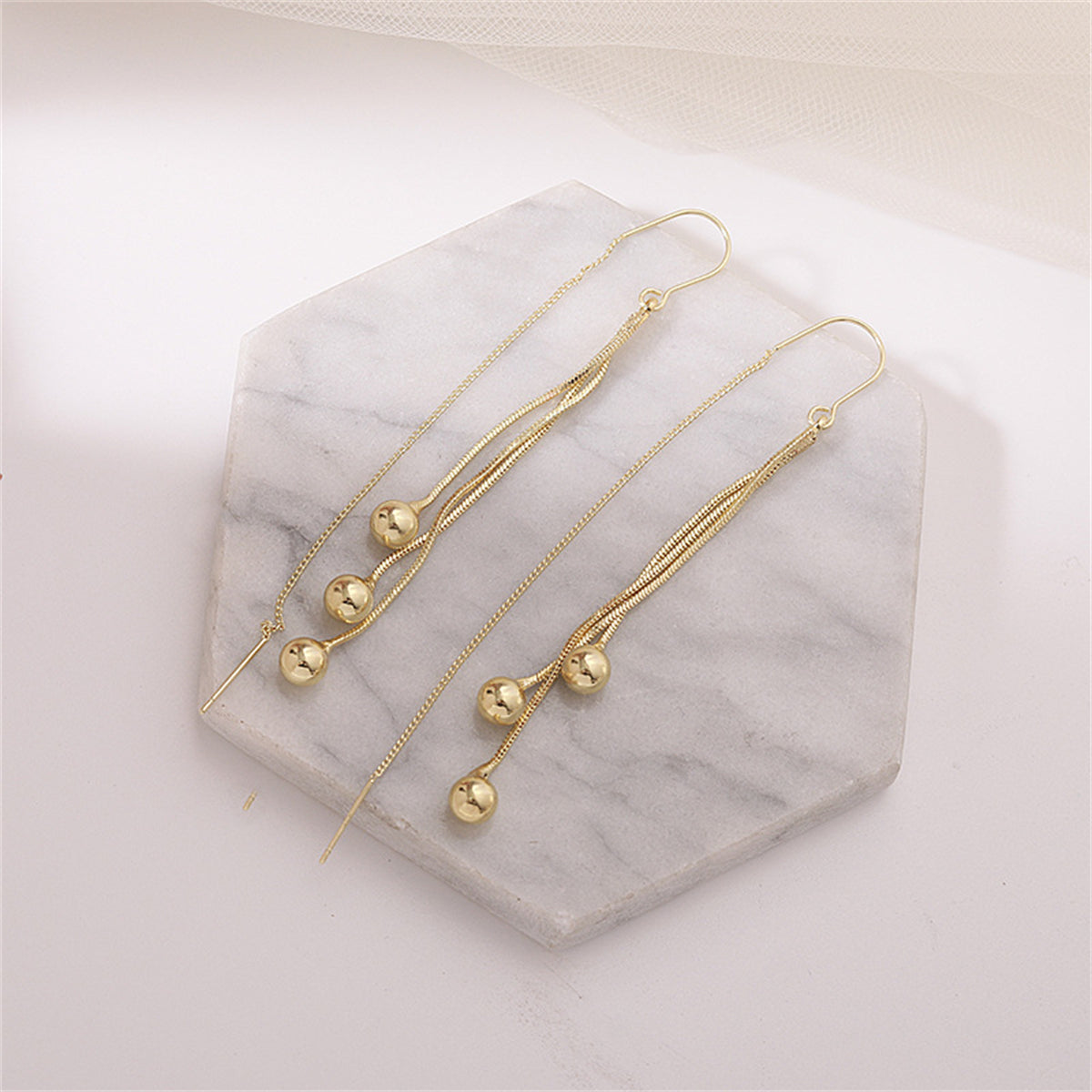 Stunning 18K gold-plated chain earrings with two beaded balls, perfect for adding a touch of elegance to any outfit.