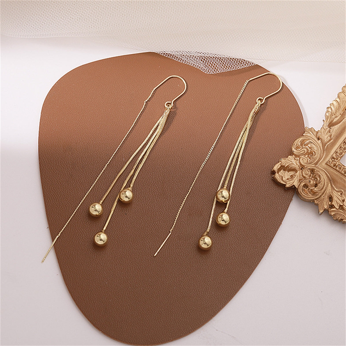 Dazzling 18K gold-plated chain earrings with two eye-catching beaded balls, perfect for elevating your style effortlessly.