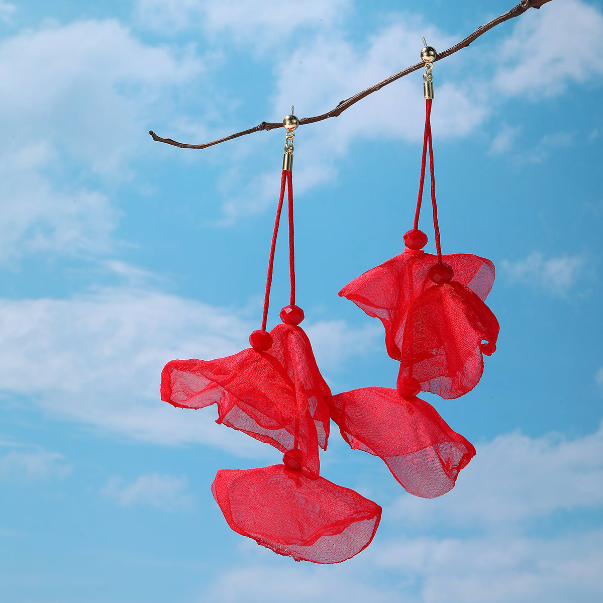 Elegant red flower earrings featuring three petals, complemented by gold-plated hooks for a sophisticated look.