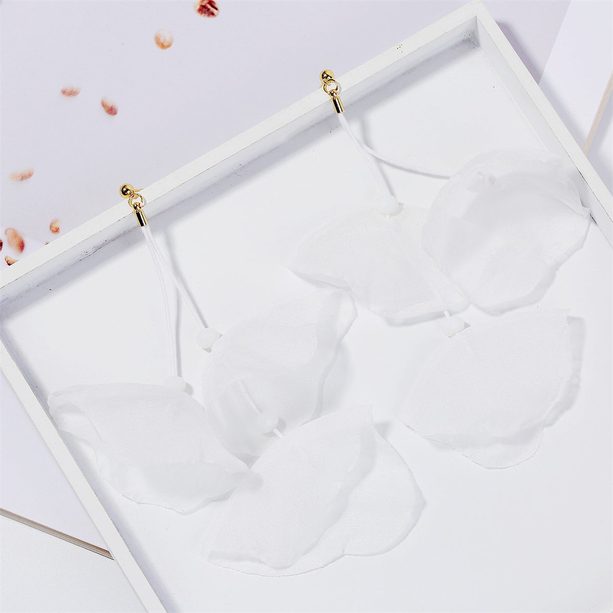 Stunning white flower earrings featuring gold hooks, combining comfort and elegance for versatile styling on any occasion.