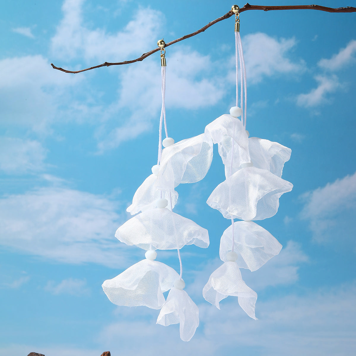 Beautiful white polyester earrings shaped like flowers, adorned with gold-plated hooks for a chic and elegant look.