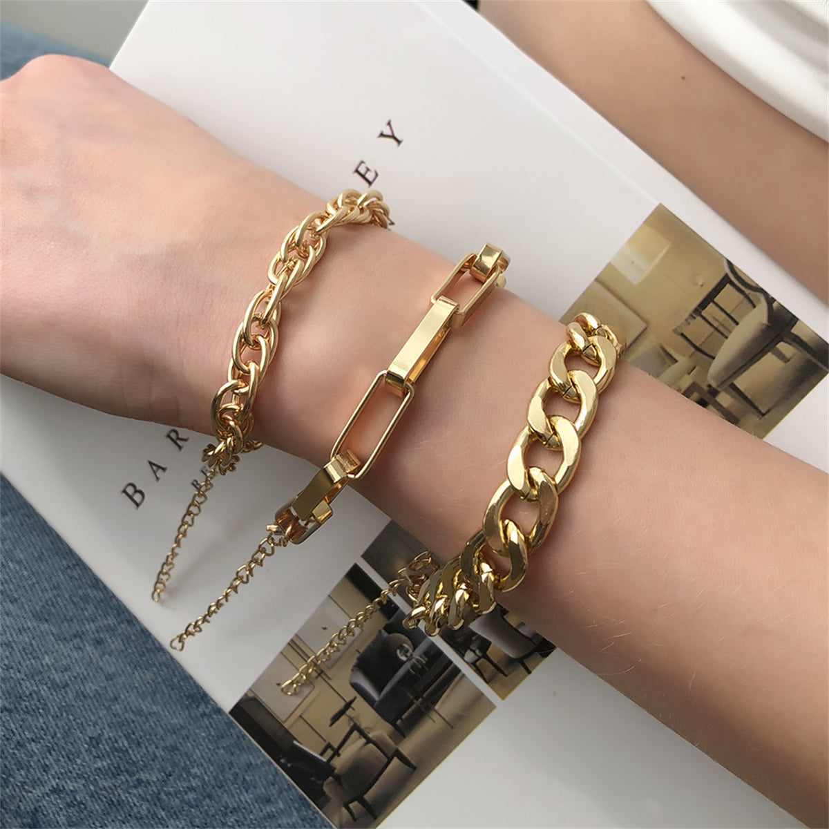 A stunning set of three 18K gold-plated chain bracelets, showcasing stylish curb and cable links for a chic accessory look.
