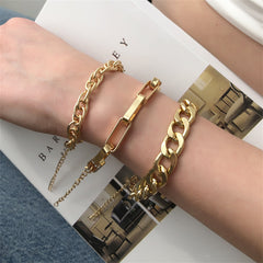 A stunning set of three 18K gold-plated chain bracelets, showcasing stylish curb and cable links for a chic accessory look.