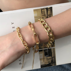 Three luxurious 18K gold-plated chain bracelets with curb and cable links, ideal for adding a touch of elegance to any outfit.