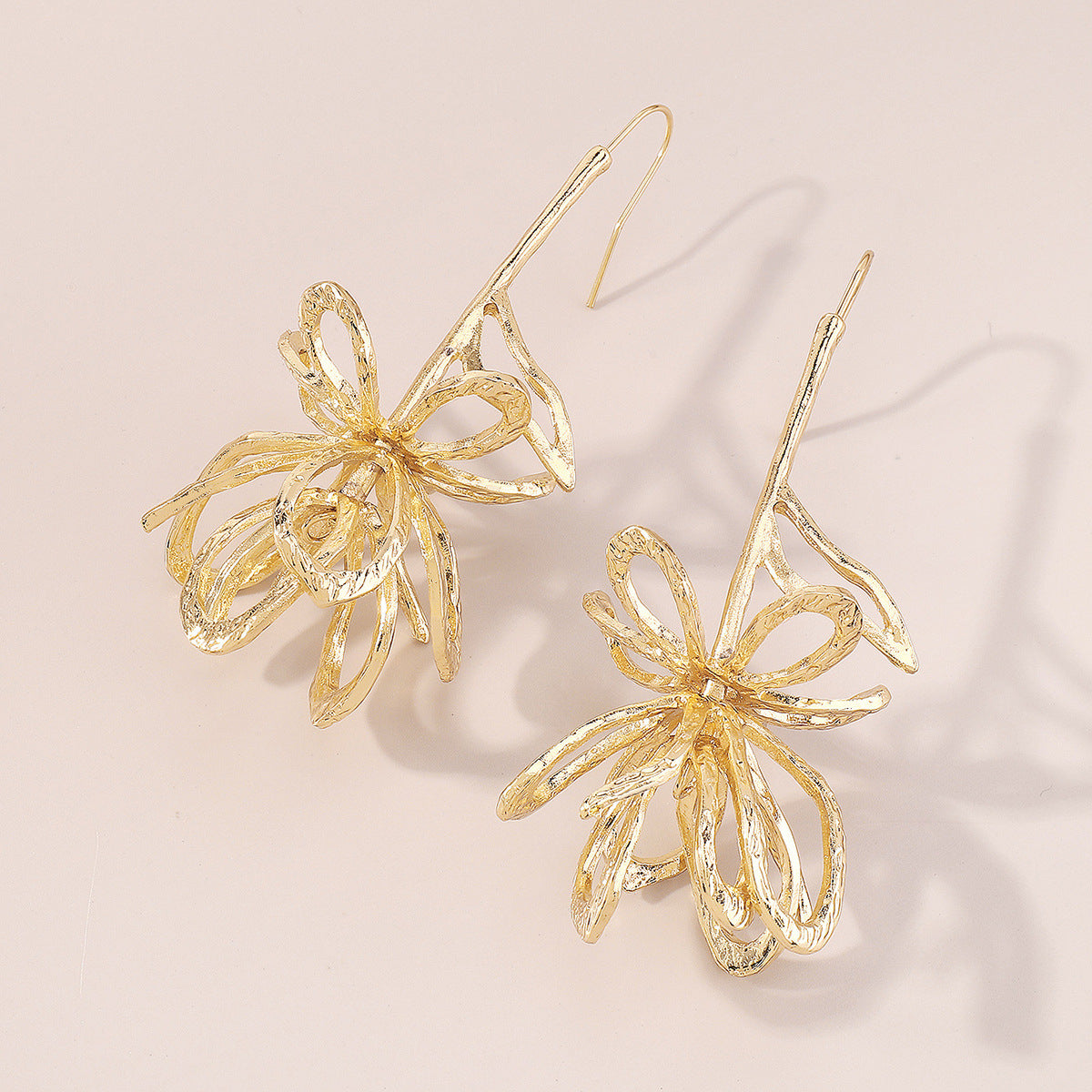 Stunning 18K gold-plated drop earrings showcasing a large, abstract flower design, perfect for any occasion.