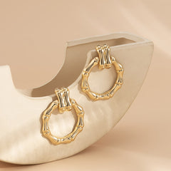 Fashionable 18K gold-plated bamboo-shaped round drop earrings designed with a sleek circular shape for modern elegance.