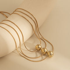 Beautiful 18K gold-plated necklace set featuring a golden ball design with three strands, perfect for any occasion.