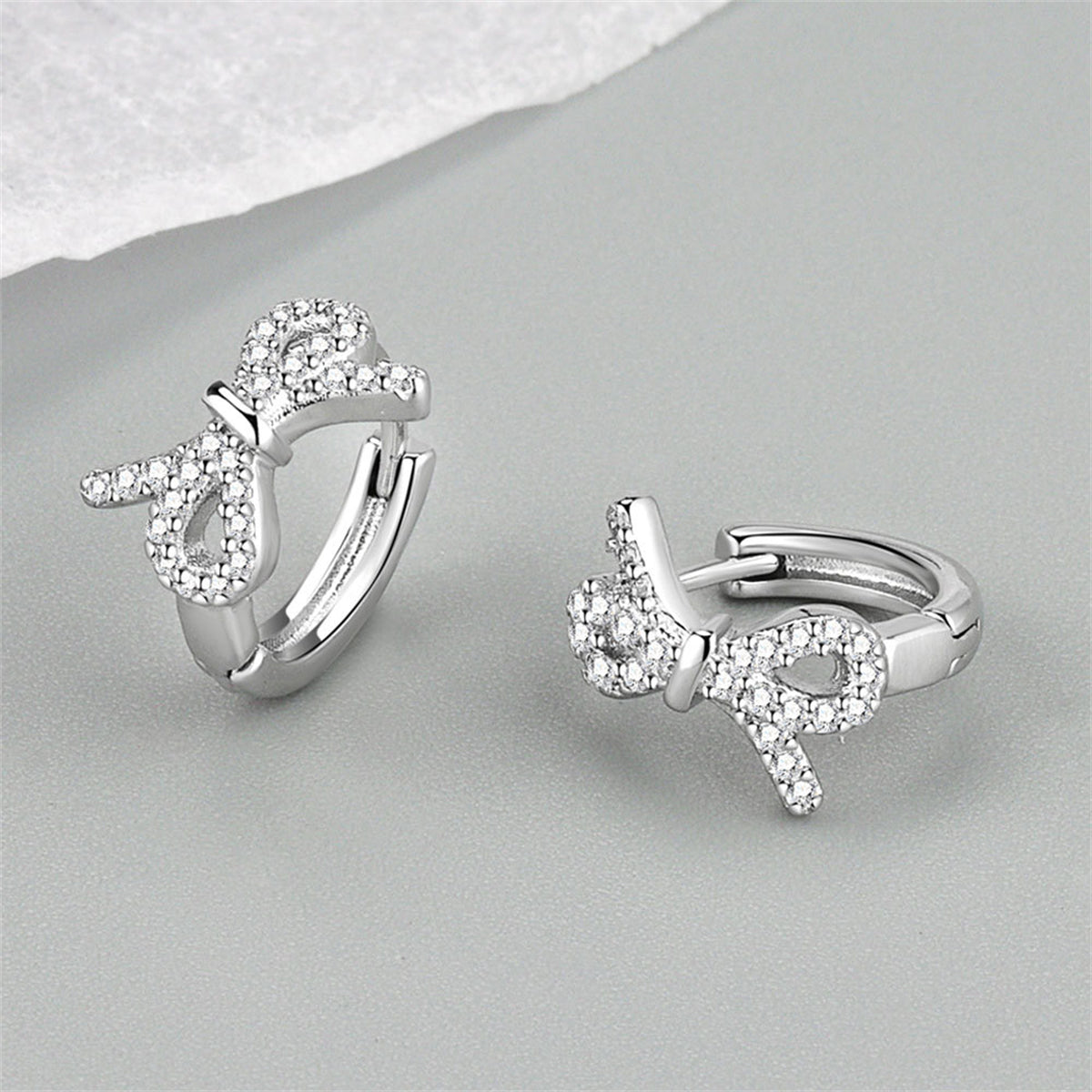 Clear Cubic Zirconia and Silver-Plated Bow Huggie Earrings, silver huggie earrings, everyday style, side view