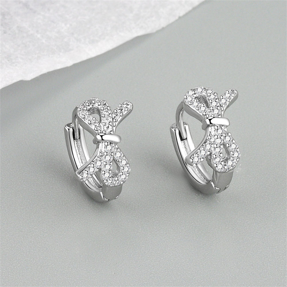 Clear Cubic Zirconia and Silver-Plated Bow Huggie Earrings, silver huggie earrings, everyday style, detail close-up