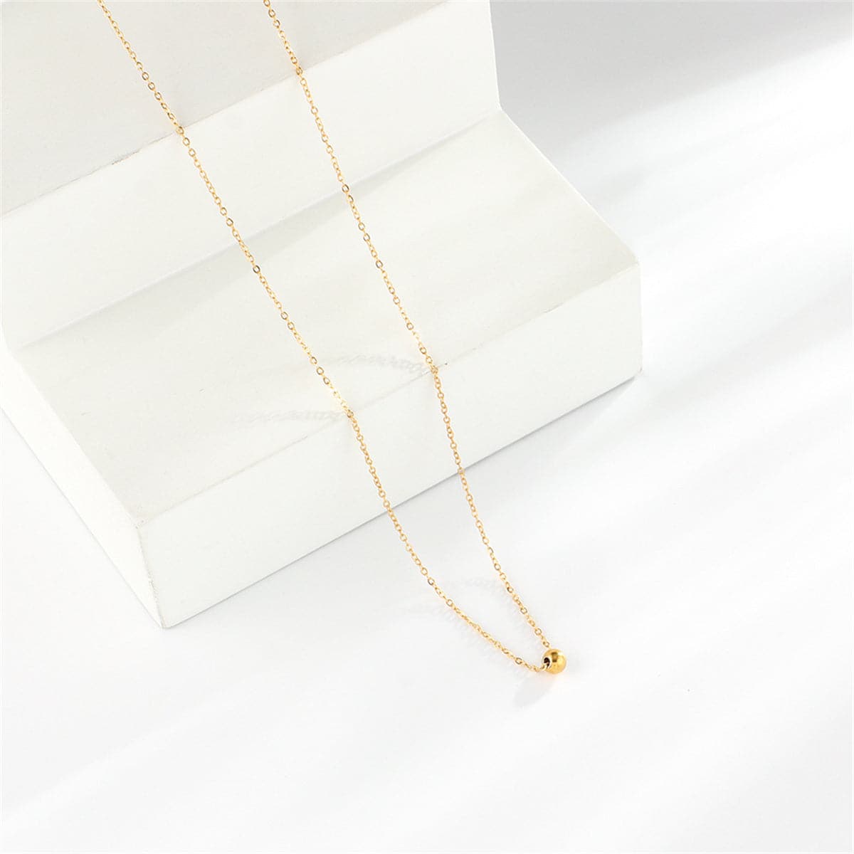 Dazzling 18K gold-plated bead pendant necklace resting on a chain, a perfect accessory for a touch of luxury and charm.