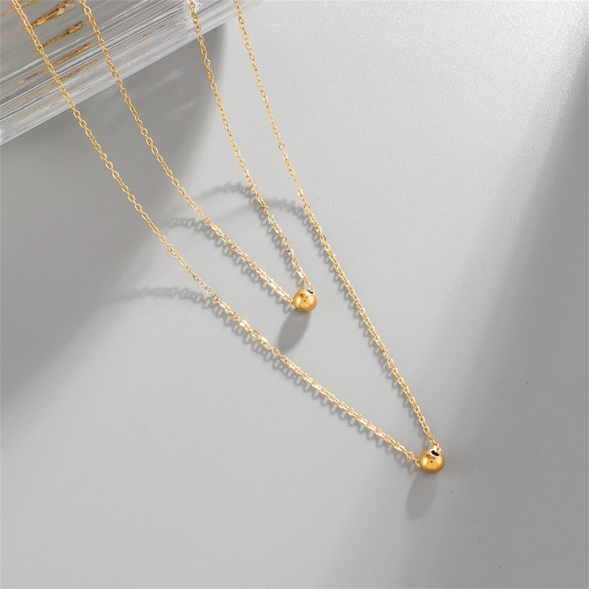 Chic double layer necklace in 18K gold plating, showcasing two exquisite gold balls for a trendy accessory.