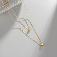 Chic double layer necklace in 18K gold plating, showcasing two exquisite gold balls for a trendy accessory.