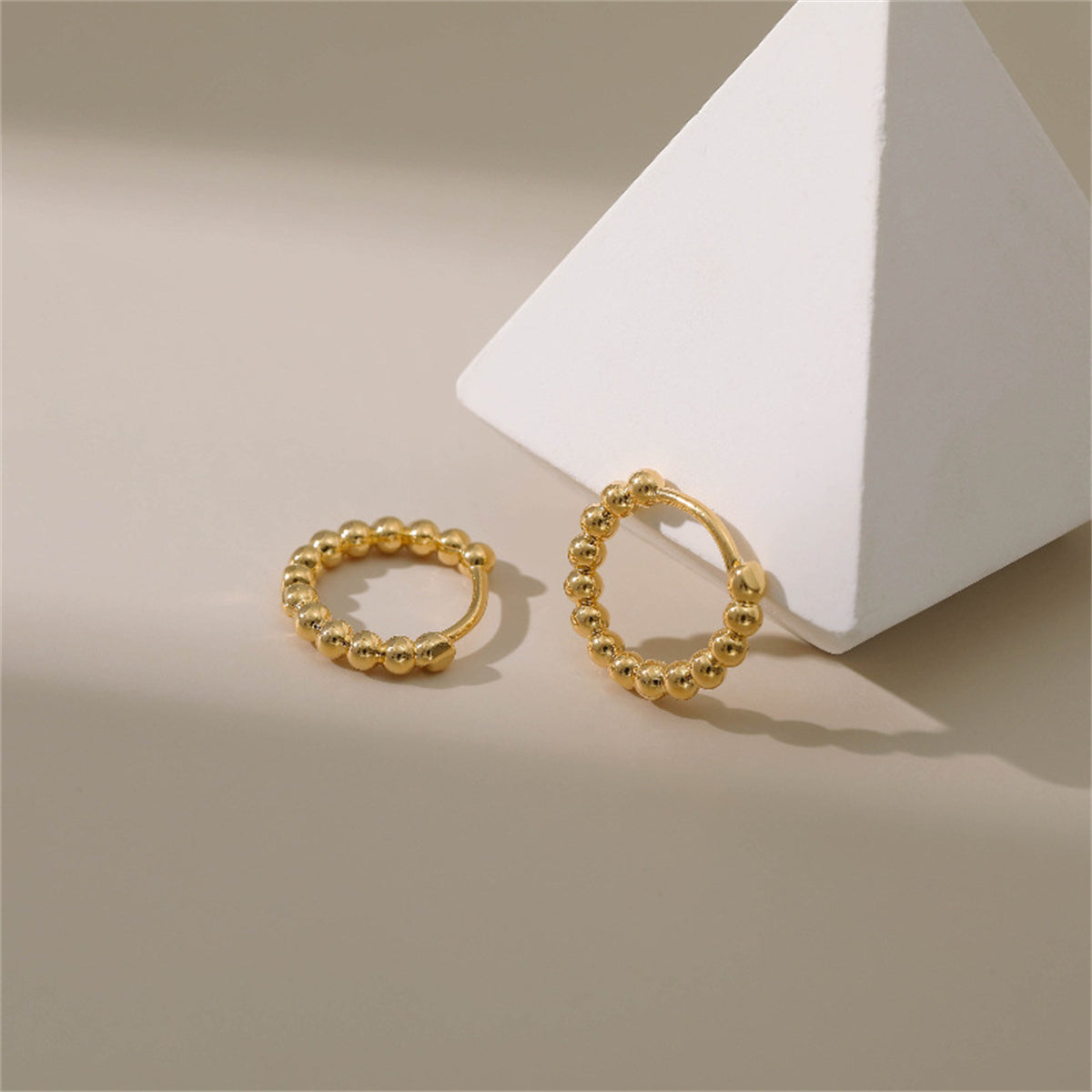 Stunning 18k gold ball hoop earrings that elevate your style with their timeless elegance and shine.