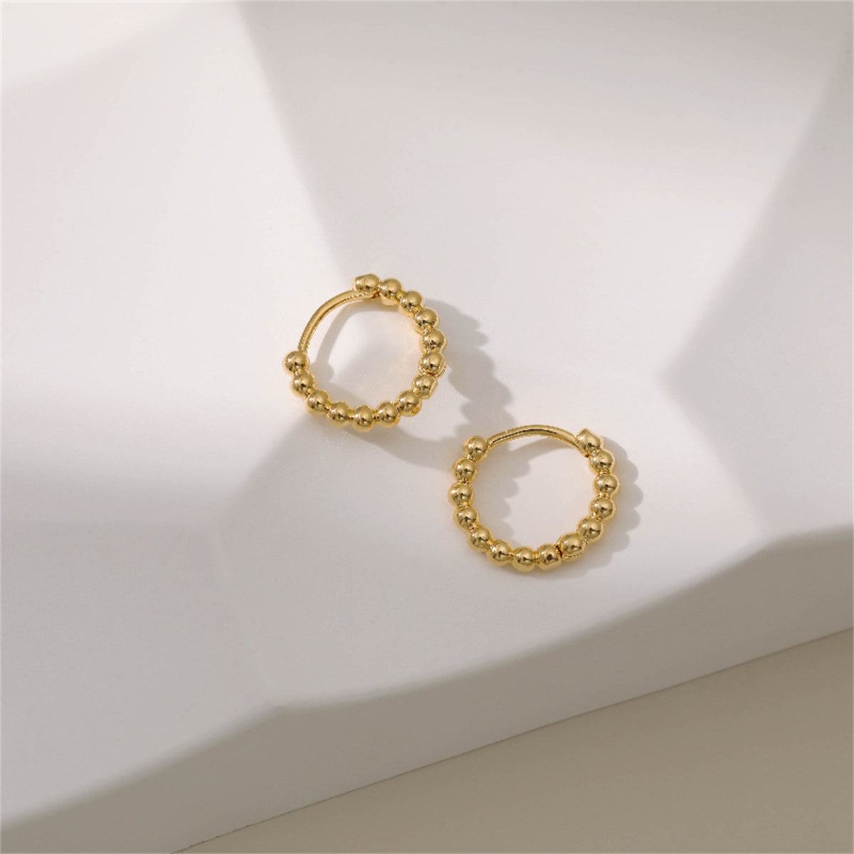 Dazzling 18k gold ball hoop earrings, ideal for making a statement and complementing any ensemble effortlessly.